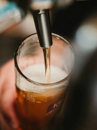 person filling clear glass with liquid